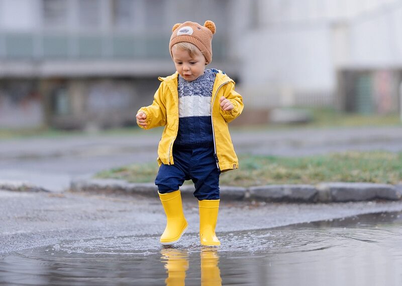 Little boy jumping in puddles