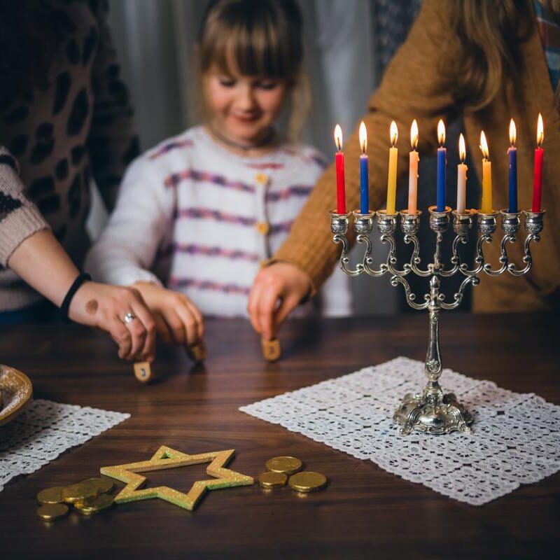 Hanukkah child playing with her family